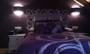 Habitación bajocubierta, con cabecero en plata , mesitas en plata.