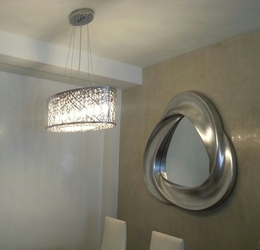 Zona de comedor , espejo plata , lámpara con cristales interiores.