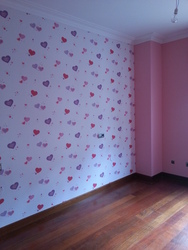 Detalle de papel pintado habitación infantil de corazones.
