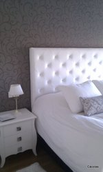 Cabecero decorado con papel pintado color taupe.