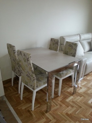 Mesa de comedor con sillas tapizadas en tela aquaclean.