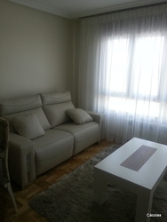 Salón comedor con mesa de centro elevable.
